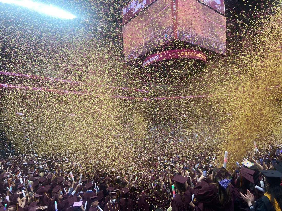 Confetti fills the air above graduates in mortarboards