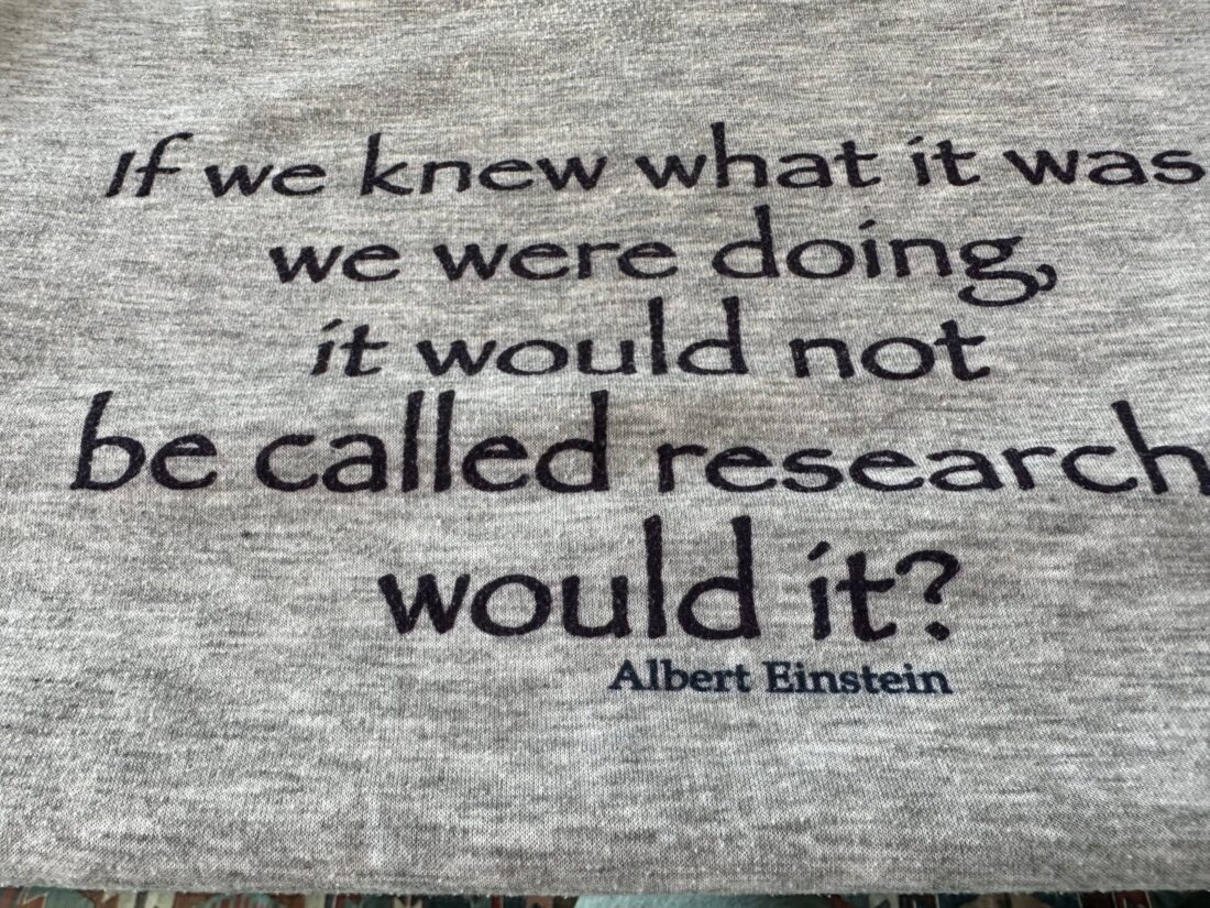 Image: Gray T-shirt with text: If we knew what it was we were doing, it wouldn't be called research would it? - Albert Einstein